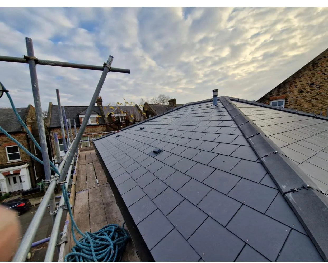 Newly installed slate roof with ridge tiles and lead flashing